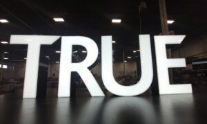 white 3D channel letters that read TRUE